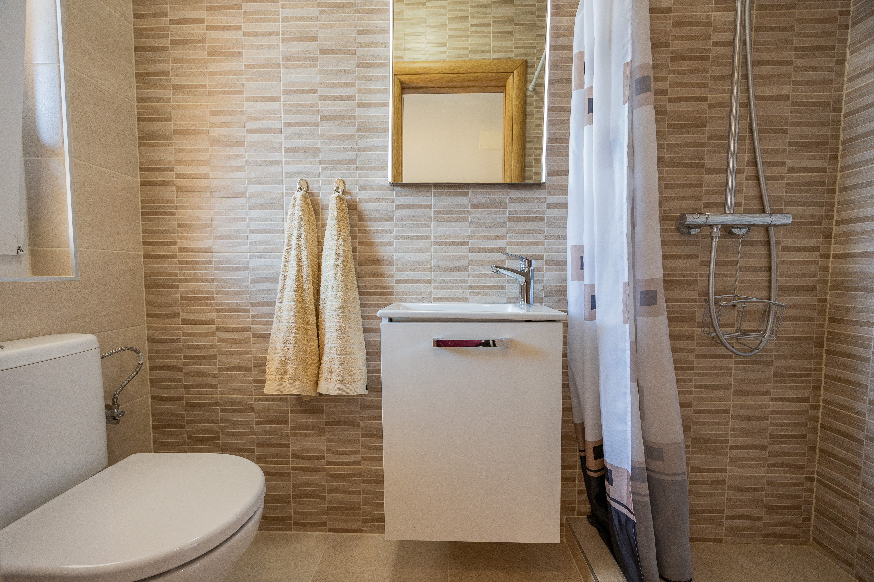 Bathroom with shower and warm tiled walls