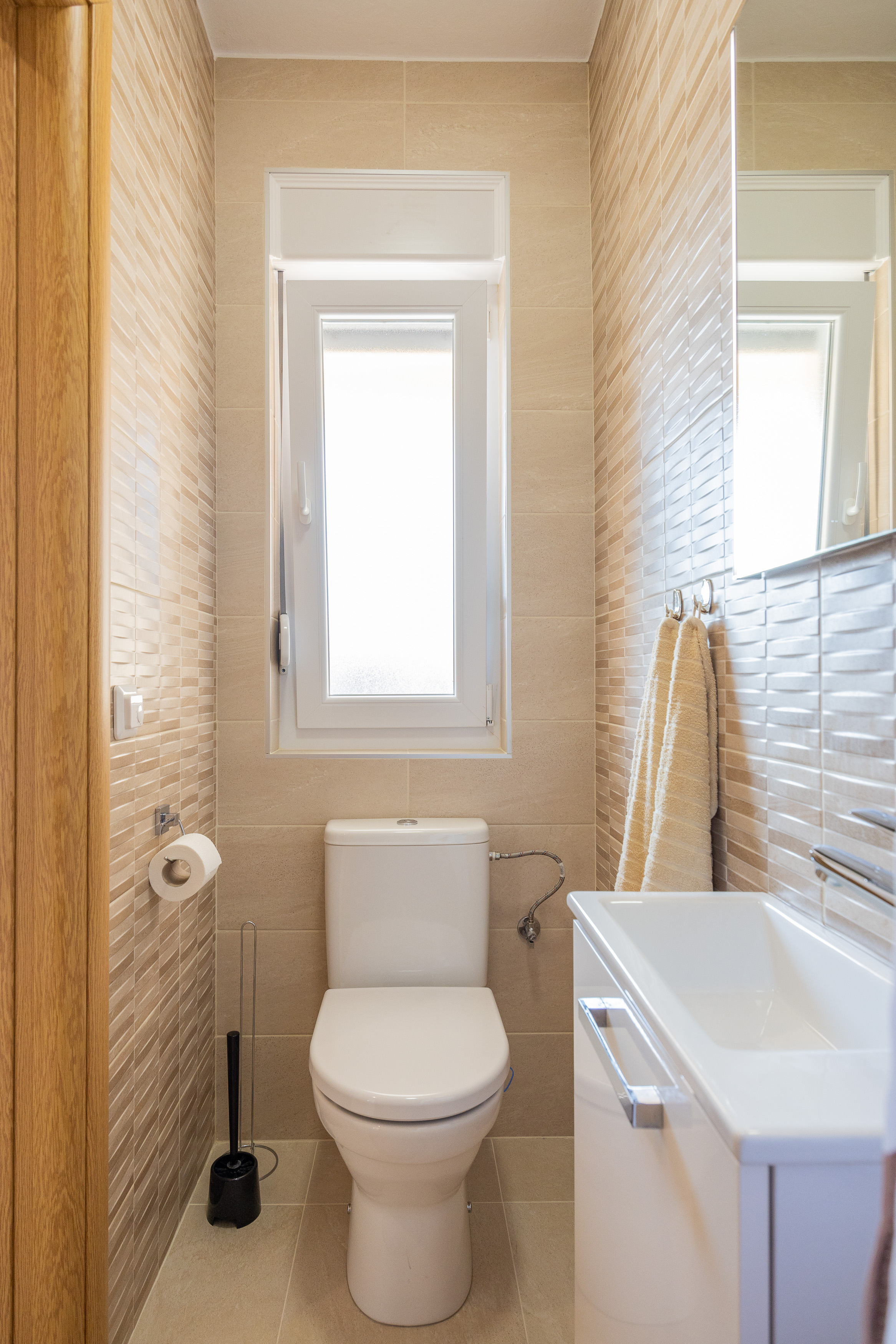 WC with window and warm tiled walls