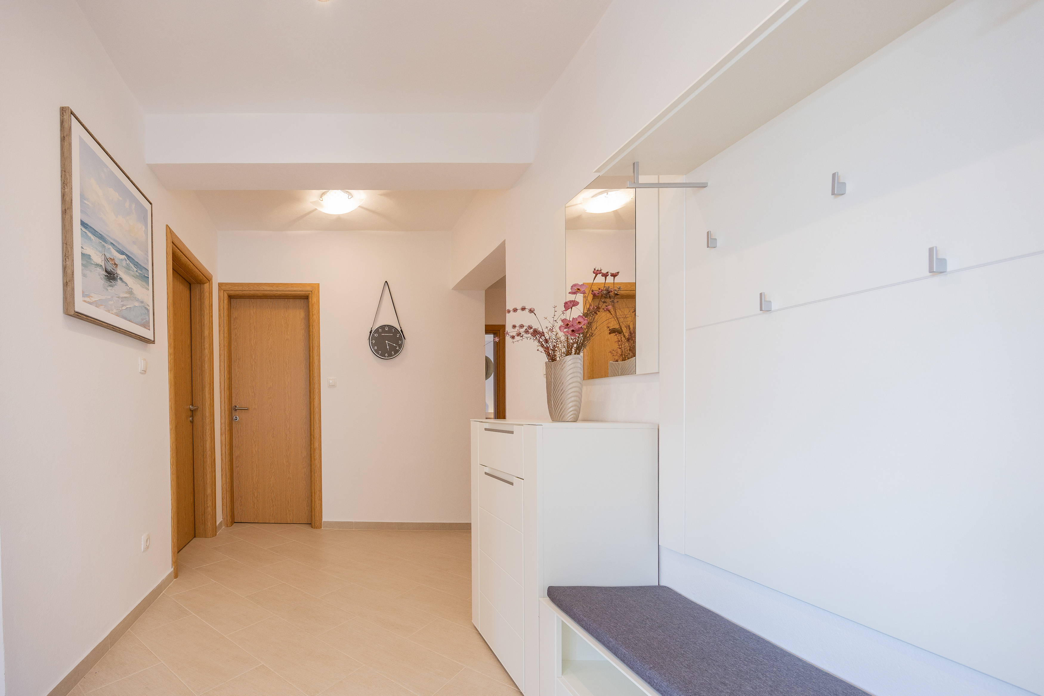 Hallway with artwork and doors to rooms
